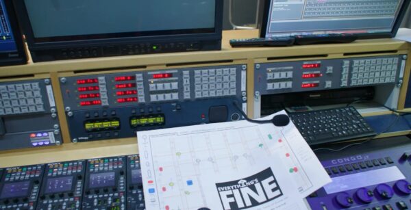 Photo of tech equipment- some screens, boards and paperwork